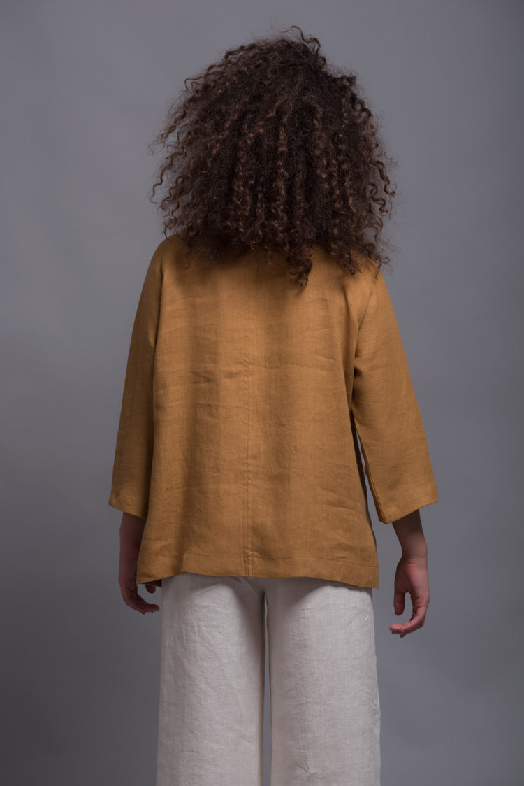 Back view of the linen blouse SOVA, showing the smooth, breathable linen fabric.