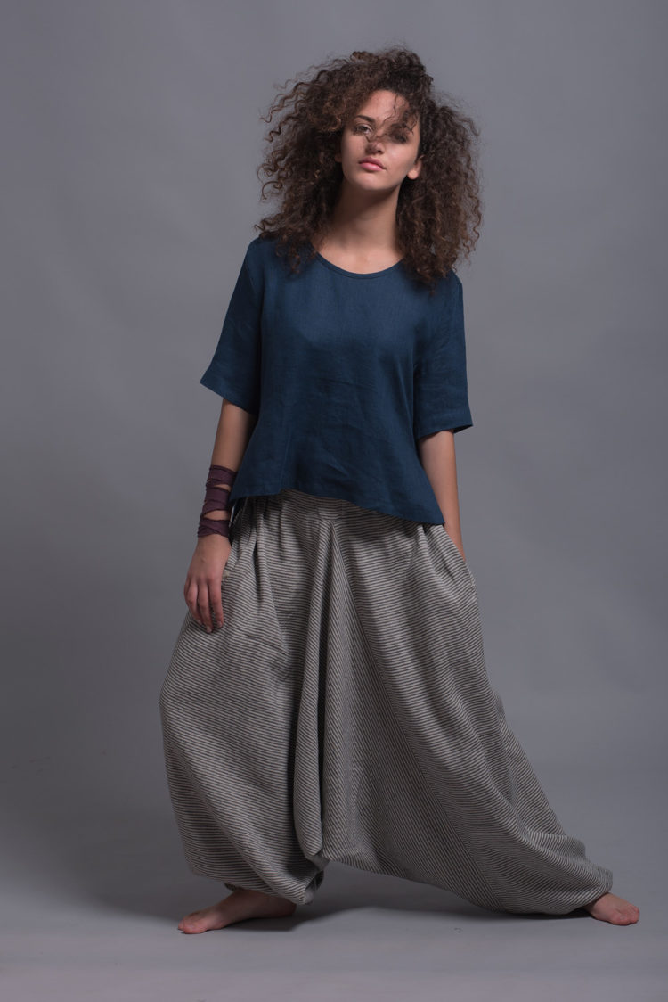 Model moving freely in the relaxed fit FRIDA shirt with casual striped harem trousers, showcasing ease of movement.
