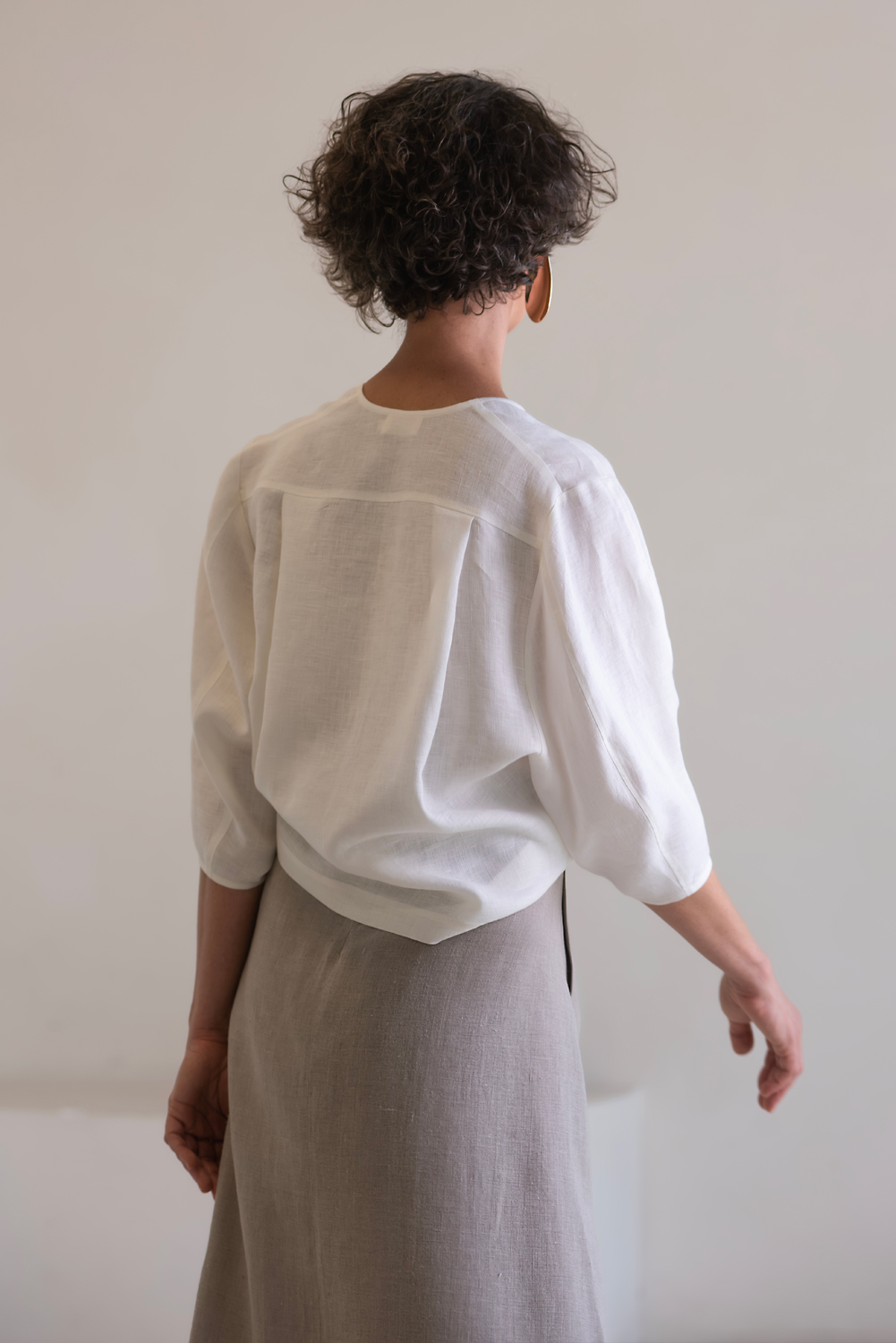 Complete linen outfit featuring a white V-neck blouse and long gray skirt, designed to create a clean, feminine and naturally elegant silhouette. Women's linen skirt and blouse set in white and natural gray