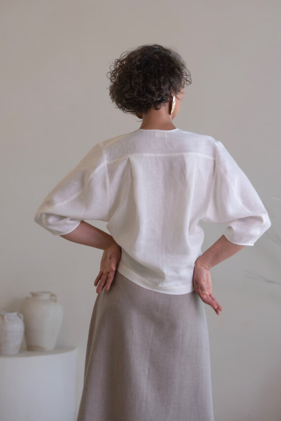 Close-up of natural linen fabric on women's white top and gray skirt