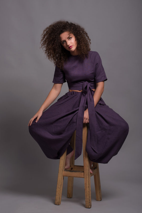 Model wearing a reversible wrap linen blouse in Royal Purple color