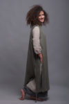 Model tying the side ties of the linen pinafore apron dress LINAS for a personalized fit.