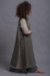 Side view of the LINAS linen pinafore dress layered over a lightweight tunic, showing its versatility.