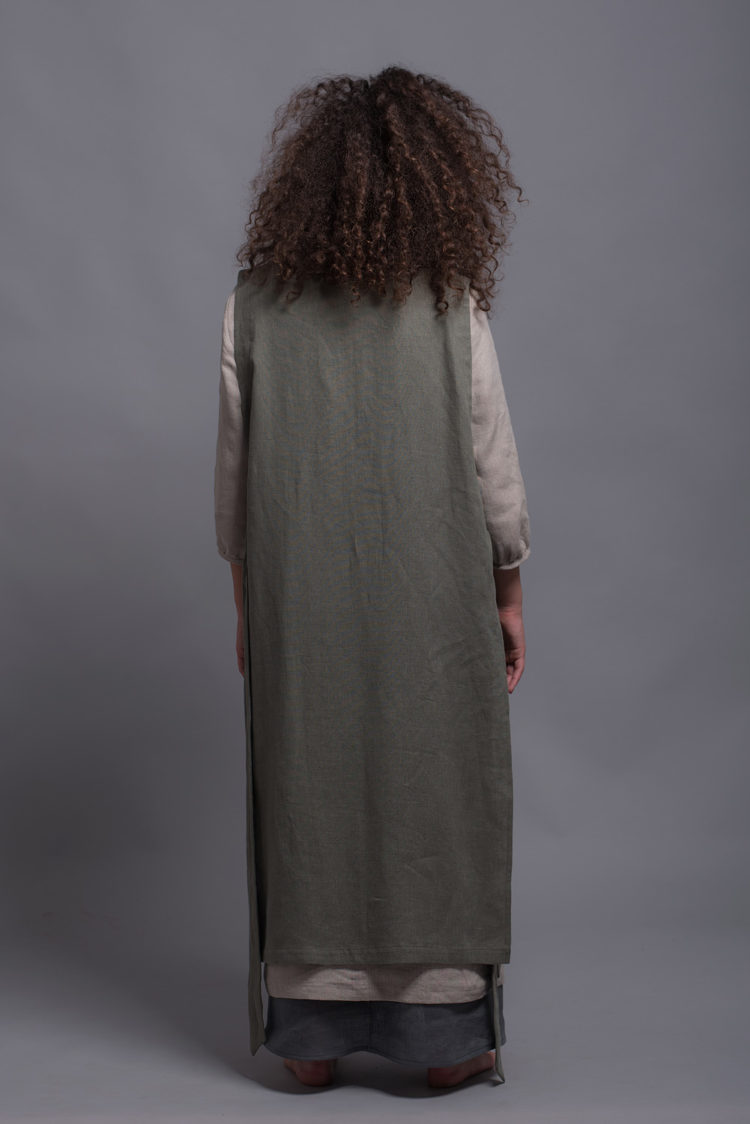 Back angle of the LINAS pinafore linen dress, emphasizing the flow and structure of the A-line design.
