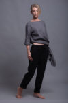 Side view of black linen tapered pants showcasing the structured yet relaxed silhouette.