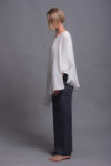 Side view of the loose-fitting two-layer linen top in lightweight milk white fabric.
