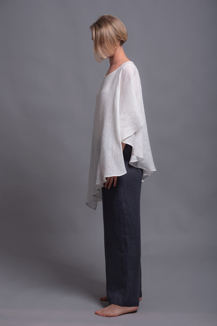 Side view of the loose-fitting two-layer linen top in lightweight milk white fabric.