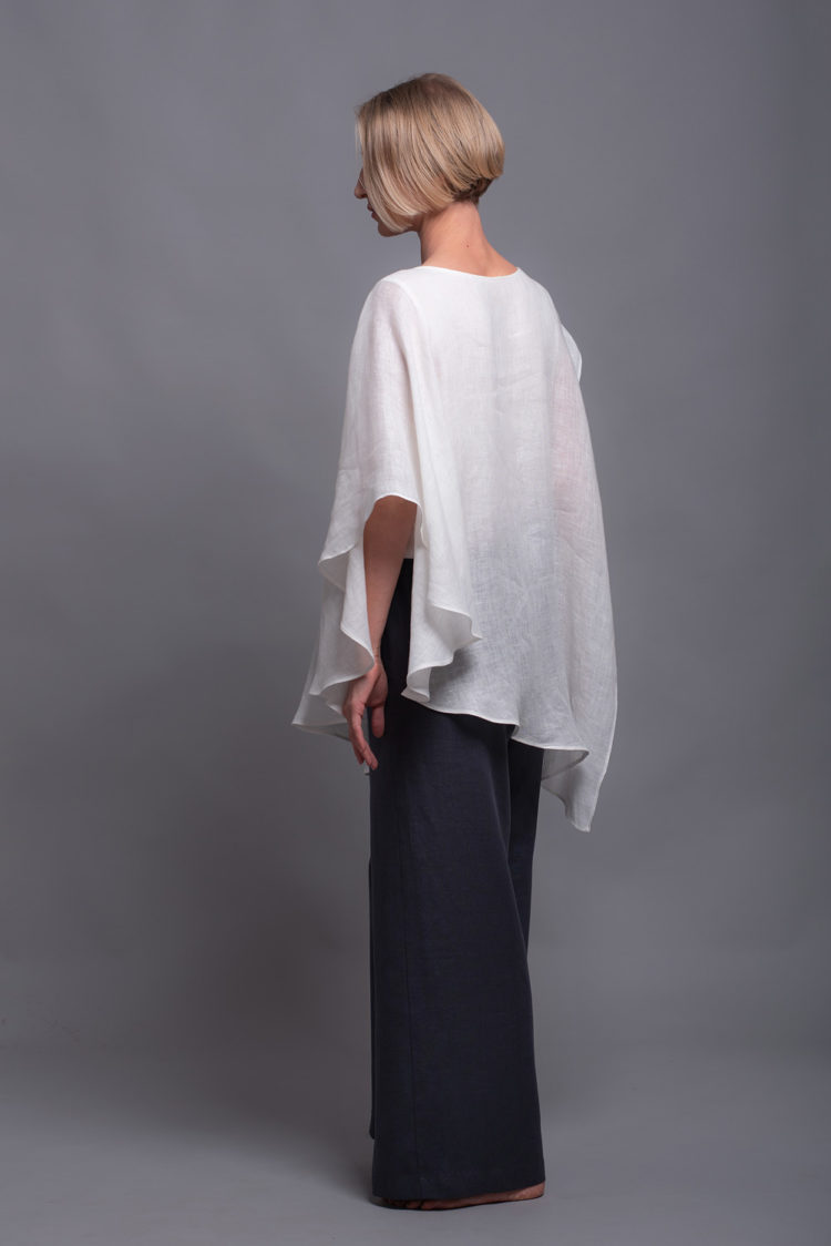 White two-layer linen top styled with linen pants for a casual summer outfit.