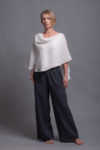 Model styling the BORA Linen Pants in Charcoal Gray with white top, showing the wide-leg fit and minimalist design