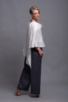Model showcasing the white linen top’s elegant, loose fit from a side angle.