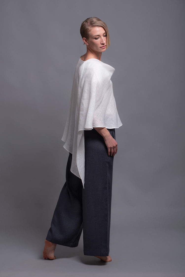 Model showcasing the white linen top’s elegant, loose fit from a side angle.