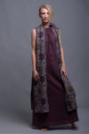 Model wearing a high slit linen vest layered over a linen dress.