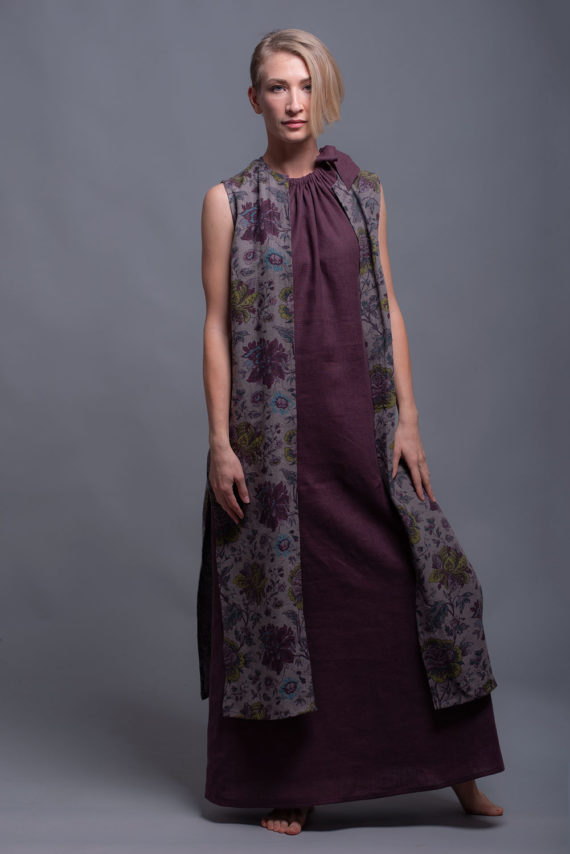 Model wearing a high slit linen vest layered over a linen dress.