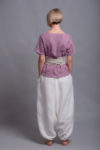 Back view showcasing the lightweight medium-weight linen fabric of the TOD blouse and white linen harem trousers.
