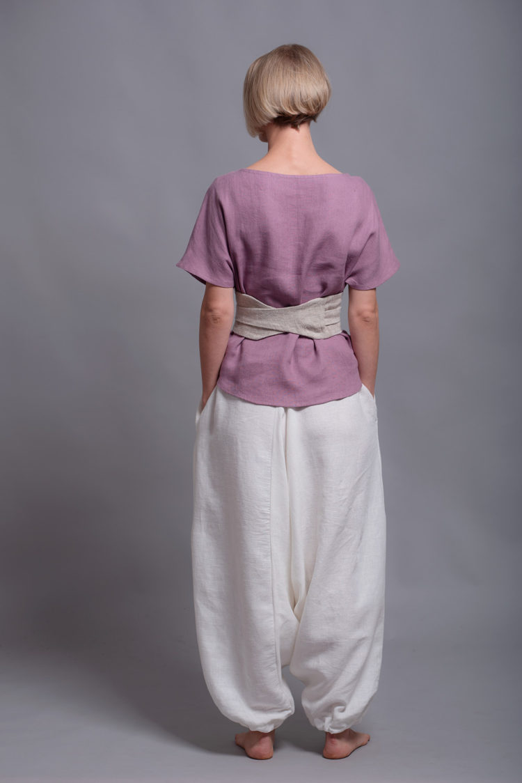 Back view showcasing the lightweight medium-weight linen fabric of the TOD blouse and white linen harem trousers.