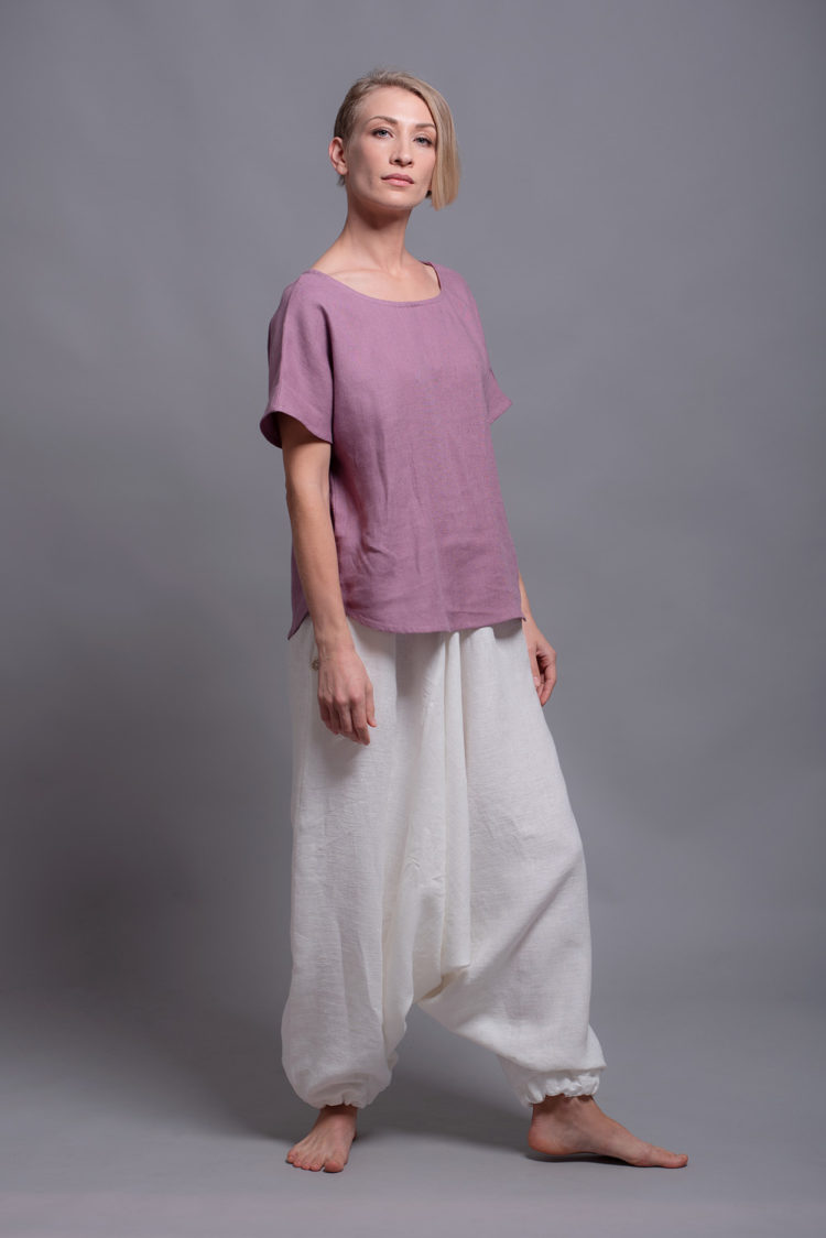 Side view highlighting rounded hem of the linen blouse TOD paired with Custom-made linen harem pants.