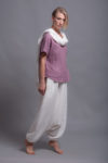 Model walking in the loose linen blouse TOD and medium-weight linen harem pants, demonstrating its comfort and ease of movement.