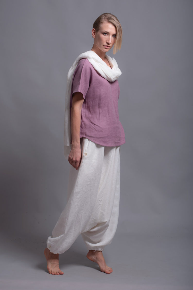 Model walking in the loose linen blouse TOD and medium-weight linen harem pants, demonstrating its comfort and ease of movement.