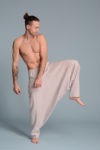 Model wearing linen harem pants while walking, demonstrating the fluid movement of the fabric