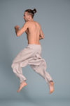 Model wearing linen harem pants while walking, demonstrating the fluid movement of the fabric