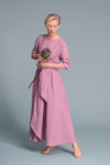 A woman wearing the TANIA dress, styled with the included wide belt for a flattering fit.