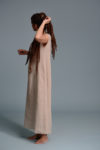 Side view of the beige linen dress showcasing its airy fabric and flowing fit.