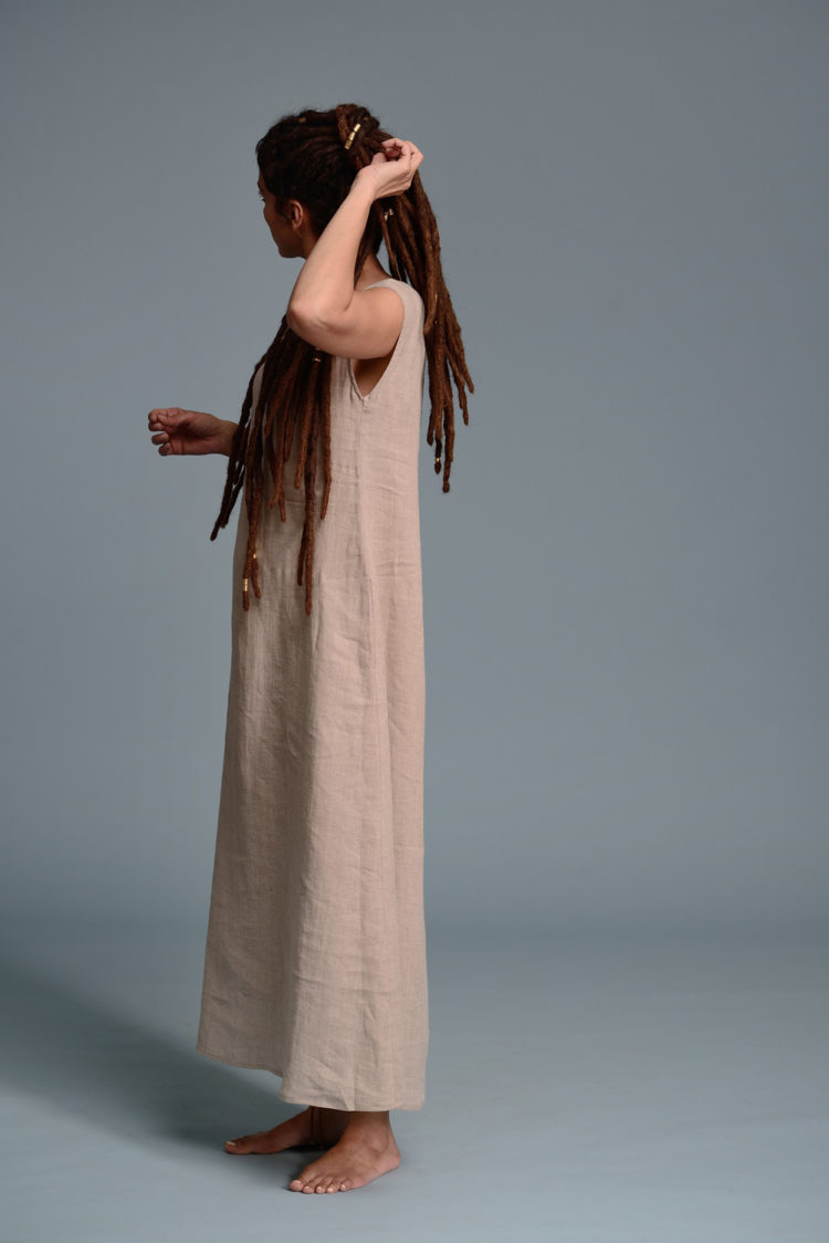 Side view of the beige linen dress showcasing its airy fabric and flowing fit.