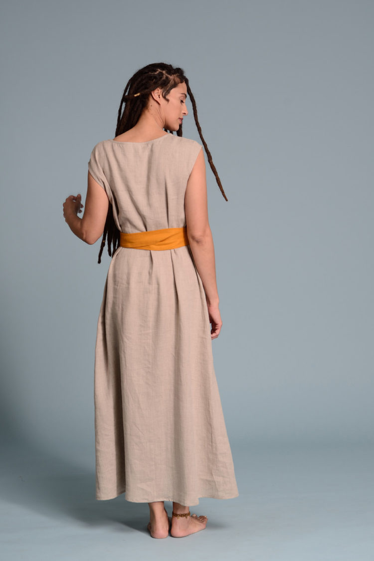 Back view of the lightweight beige linen dress highlighting its elegant simplicity.