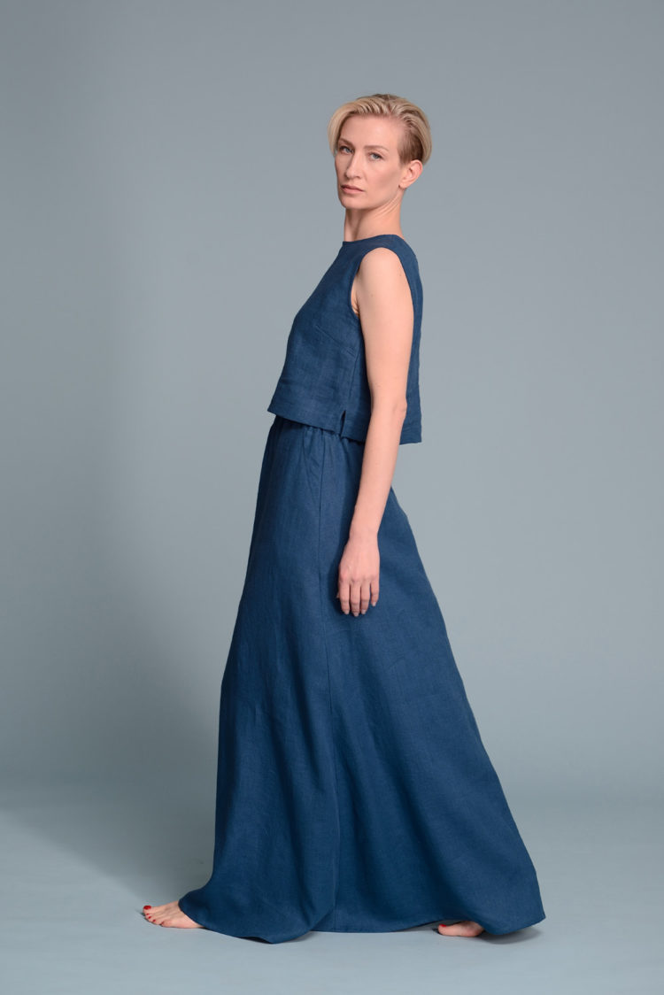 Model wearing the turquoise blue linen tank top styled with high-waisted skirt for a casual look.