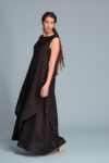 Side profile of the EFRAT linen dress, showcasing its asymmetrical hem and flowing double layers