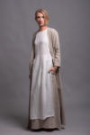 Model wearing the white tunic dress layered over linen skirt with long jacket for a casual look.