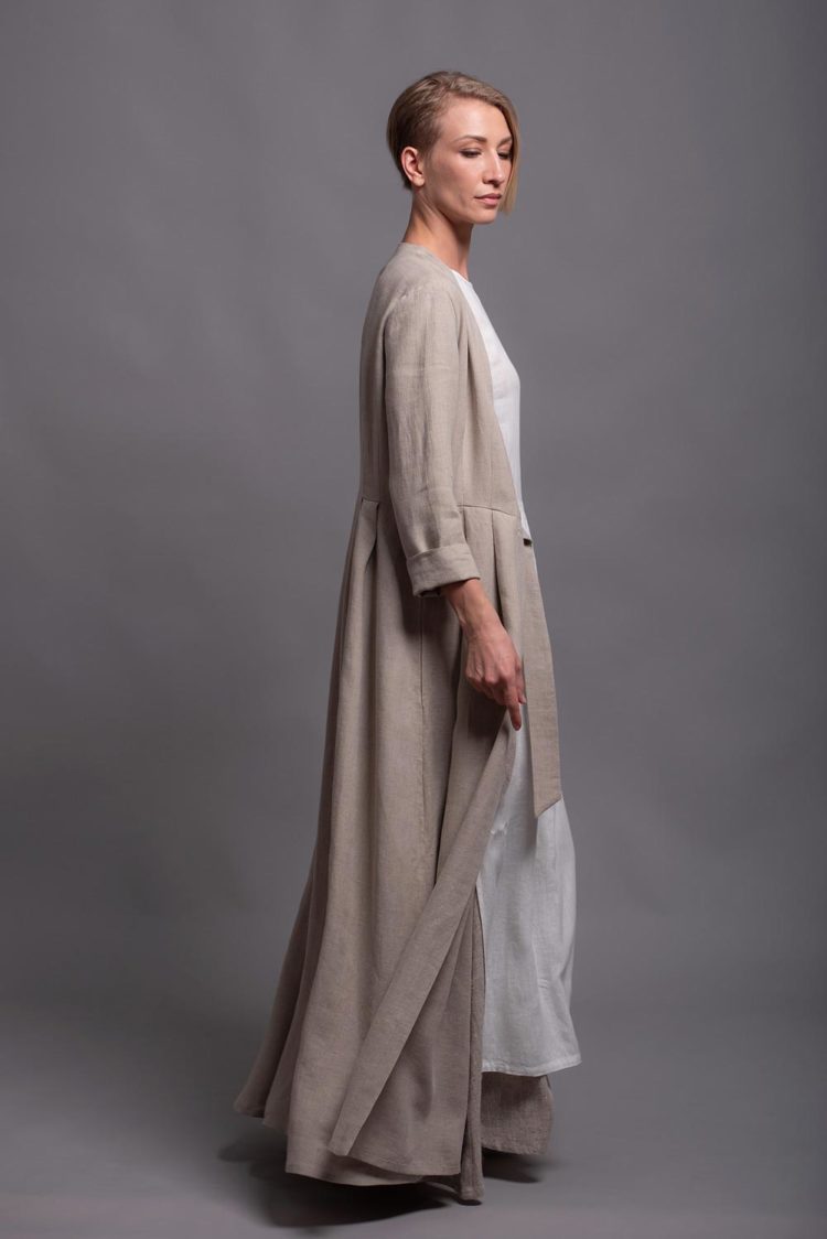 Side view of a long sleeve linen coat with narrow sleeves and an open front.
