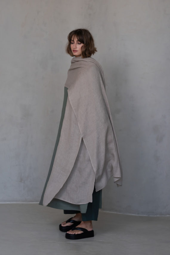 Minimalist natural flax scarf styled as a shawl with a flowing, airy texture.