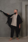 A man in motion, wearing the DUKAY loose linen jacket in black, showcasing its lightweight and breathable fabric.